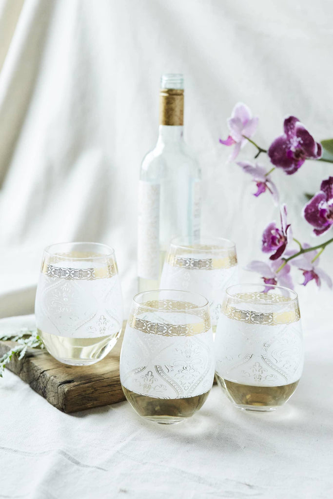 Patina Vie White Gem Stemless Wine Glass with wine bottle and orchid